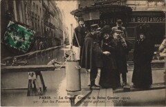 Inondations 1910 Paris sur les passerelles un agent galant
