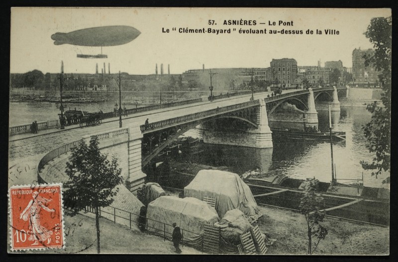 Carte postale ancienne Le Pont. Le "Clément-Bayard" évoluant au-dessus de la ville à Asnières-sur-Seine
