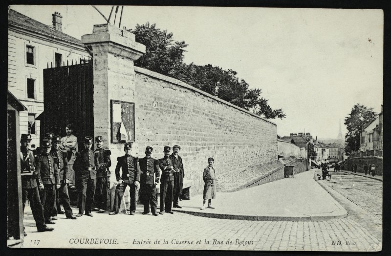 Carte postale ancienne Entrée de la caserne et la Rue de Bezon à Courbevoie