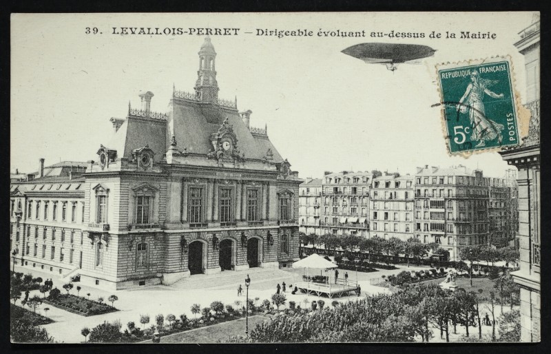 Carte postale ancienne Dirigeable évoluant au-dessus de la Mairie à Levallois-Perret