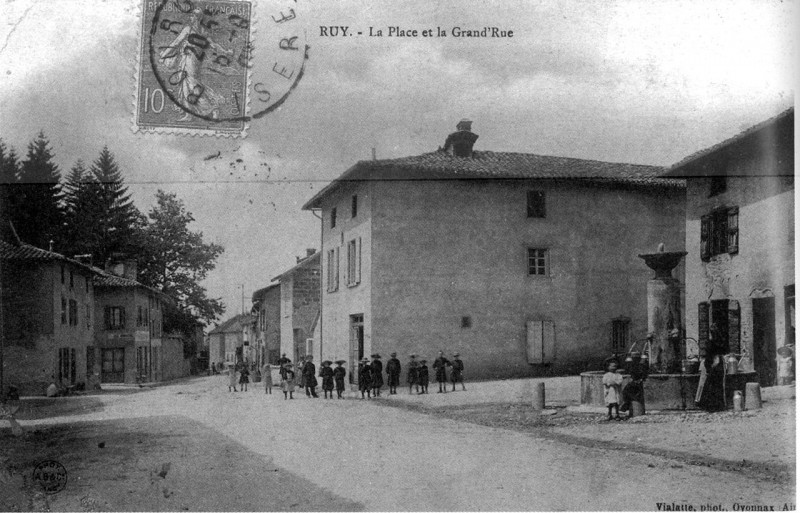 Carte postale ancienne Ruy, la place et la Grand'Rue en 1907, p180 de L'Isère les 533 communes - Vialatte phot Oyonnax, Ain