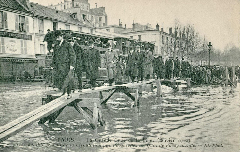 Carte postale ancienne La Grande Crue de la Seine - Passerelles établies au Quai de Passy pour permettre la circulation à Paris 16e