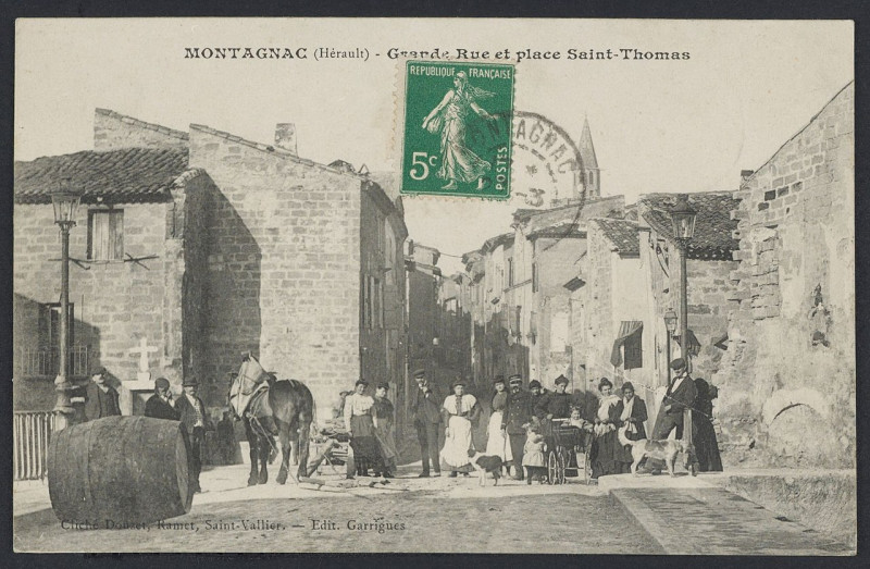 Carte postale ancienne Montagnac grande rue et place Saint Thomas - Archives départementales de l'Hérault - FRAD034-2FICP-01467-00001