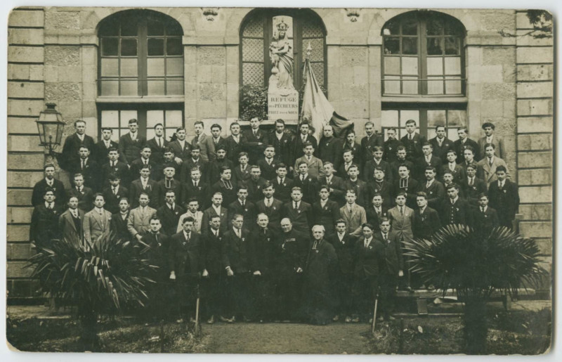 Carte postale ancienne [RENNES. - Groupe d'hommes et de prêtres posant devant une façade et une statue de la vierge avec l'inscription Refuge des Pecheurs Priez pour NOUS]
