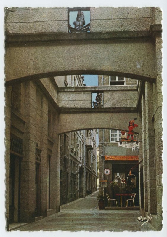 Carte postale ancienne Saint-Malo pittoresque - La Rue Thévenard. (L'enseigne est de D.Lailler et les statues en grès émaillé de Bizette, céramiste).