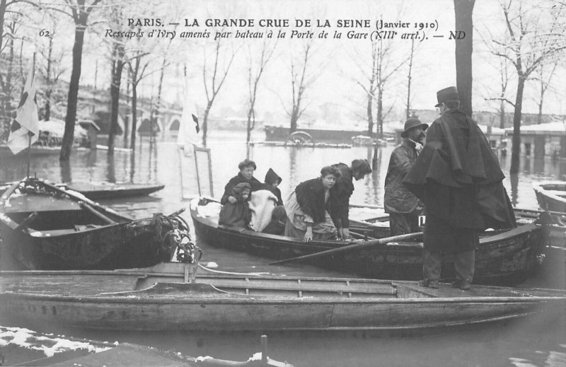Carte postale ancienne La Grande Crue de la Seine - Rescapés d'Ivry amenés par bateau à la Porte de la Gare à Paris 13e
