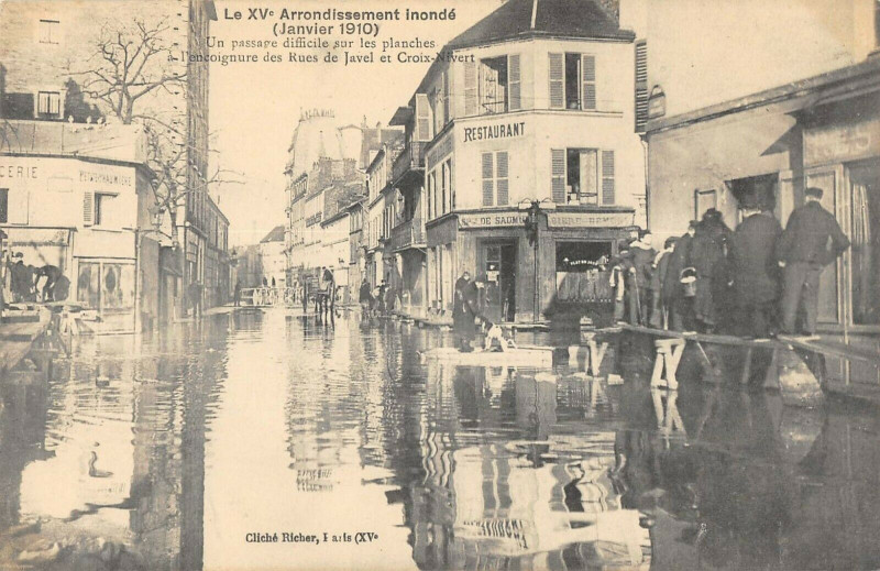 Carte postale ancienne Le XVe Arrondissement inondé (Janvier 1910) - Un Passage difficile sur les planches à l'encoignure des rues Javel Croix-Nivert à Paris 15e