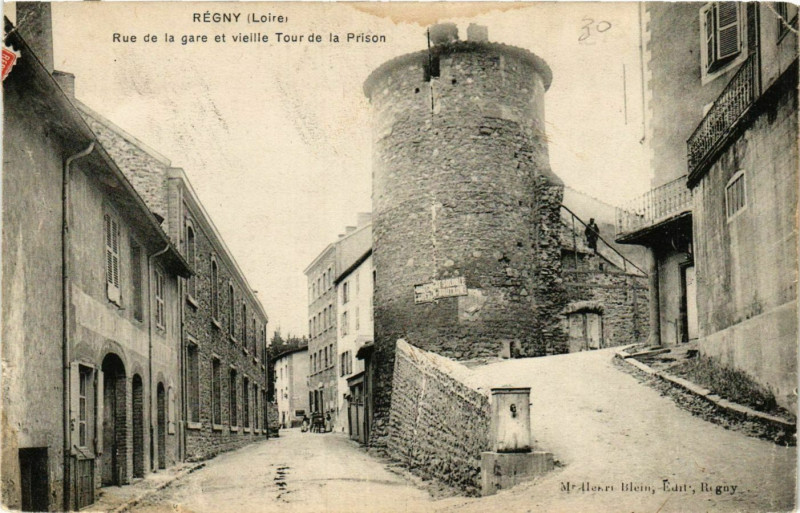 Carte postale ancienne Regny- Rue de la gare et vieille Tour de la Prison à Régny