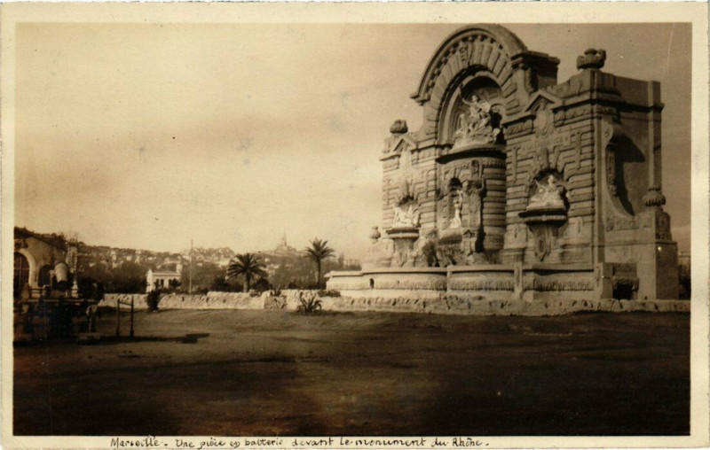 Carte postale ancienne Marseille - Une piece et batterie devant le monument du Rhone à Marseille