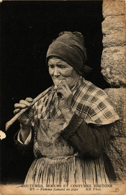 Carte postale ancienne Coutumes Moeurs et Costumes Bretons - Femme fumant sa pipe