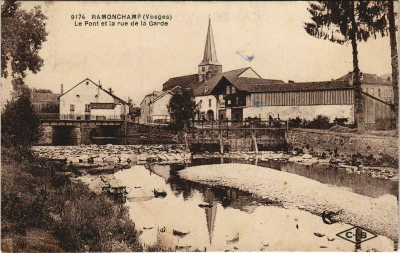 Carte postale ancienne Ramonchamp - Le pont et la rue de la garde à Ramonchamp