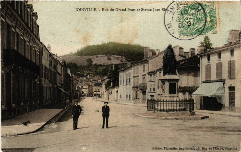 Carte postale ancienne Joinville - Rue du Grand Pont et Statue Jean Sire à Joinville