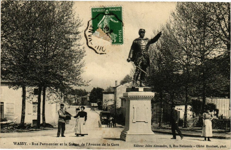 Carte postale ancienne Wassy - Rue Parmentier et la Statue de l'Avenue de la Gare à Wassy