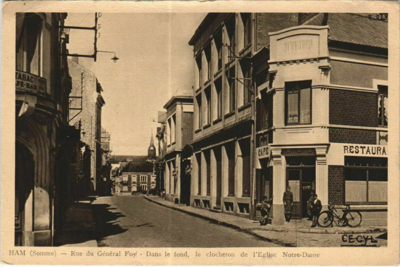 Carte postale ancienne Rue du Général Foy - Dans le fond, le clocher de l'Eglise Notre-Dame à Ham