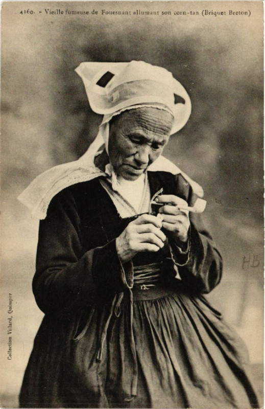 Carte postale ancienne Vieille fumeuse de Fouenant allumant son corn-tan - Folklore