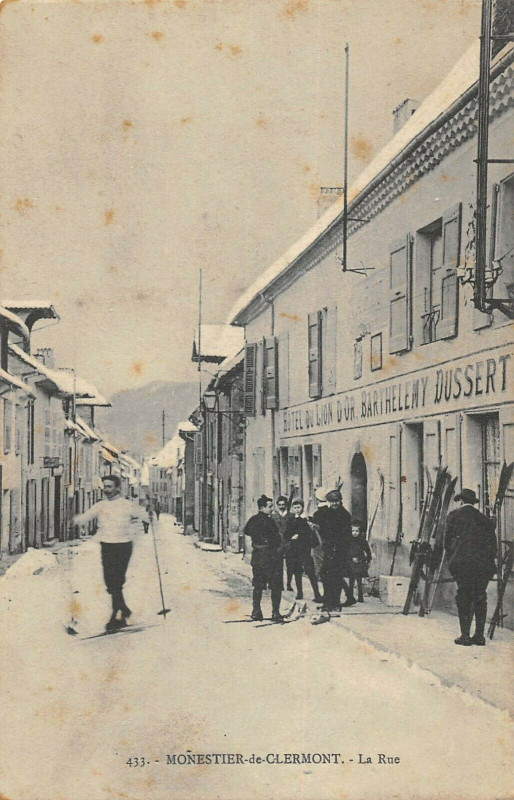 Carte postale ancienne Monestier De Clermont La Rue Skieurs Hotel Du Lion D'Or B.dussert à Monestier-de-Clermont