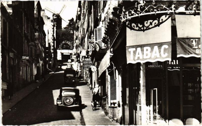 Carte postale ancienne La Rue Tholozé et le Moulin de la Galette à Paris 18e